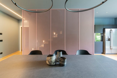 Imagen de comedor actual grande abierto con paredes rosas y suelo de madera clara