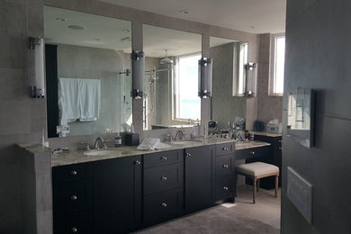 Photo of a large transitional master bathroom in Tampa with shaker cabinets, black cabinets, a drop-in tub, a corner shower, gray tile, ceramic tile, grey walls, porcelain floors, an undermount sink, marble benchtops, beige floor and a hinged shower door.