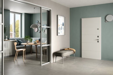 Ispirazione per una porta d'ingresso design con una porta bianca e pavimento grigio