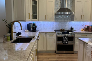 Open concept kitchen - mid-sized transitional u-shaped open concept kitchen idea in Other with an undermount sink, shaker cabinets, quartzite countertops, beige backsplash, porcelain backsplash, stainless steel appliances and an island