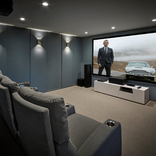 Example of a trendy carpeted and gray floor home theater design in Edmonton with gray walls and a projector screen