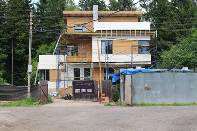 На фото: разноцветный частный загородный дом среднего размера в современном стиле с разными уровнями, комбинированной облицовкой, односкатной крышей и крышей из гибкой черепицы