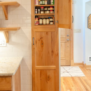 Klassisk inredning av ett mellanstort kök, med skåp i shakerstil, skåp i mellenmörkt trä, en undermonterad diskho, granitbänkskiva, vitt stänkskydd, stänkskydd i porslinskakel, rostfria vitvaror och mellanmörkt trägolv