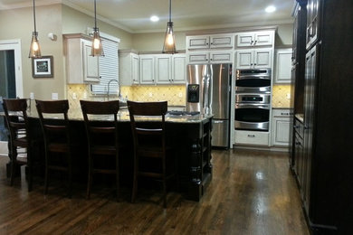 Large elegant u-shaped dark wood floor and brown floor eat-in kitchen photo in Kansas City with raised-panel cabinets, dark wood cabinets, granite countertops, beige backsplash, cement tile backsplash, stainless steel appliances, a peninsula, an undermount sink and gray countertops