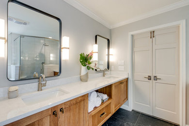 Example of a large transitional master gray tile and subway tile double-sink bathroom design in Oklahoma City with shaker cabinets, medium tone wood cabinets, a one-piece toilet, an undermount sink, quartz countertops, a hinged shower door and a floating vanity