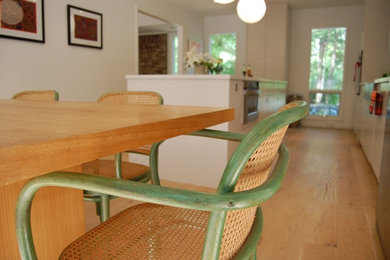 Eat-in kitchen - large contemporary single-wall light wood floor eat-in kitchen idea in Raleigh with flat-panel cabinets, white cabinets and an island