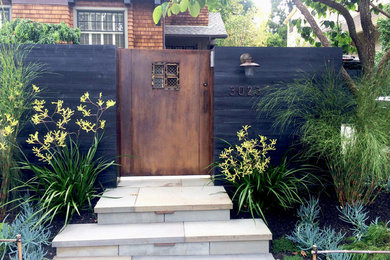 Photo of a modern front yard partial sun garden for spring in San Francisco with with a gate and natural stone pavers.