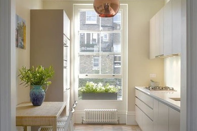 Ispirazione per una cucina lineare minimalista chiusa con lavello sottopiano, ante lisce, ante bianche, top in quarzo composito, paraspruzzi bianco, elettrodomestici bianchi, pavimento in legno massello medio, pavimento multicolore e top bianco