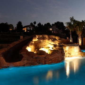 Backyard porch and pool with waterfall and slide.