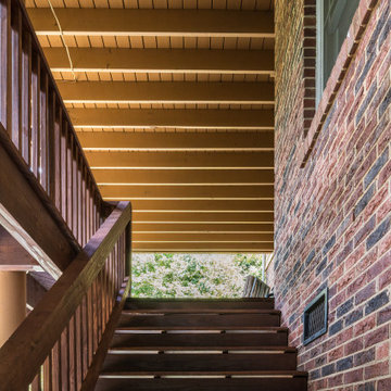 Wood Staircase with Under-Deck Cover and Brick Accent Wall