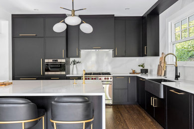 Inspiration for a contemporary l-shaped dark wood floor and brown floor eat-in kitchen remodel in Vancouver with a drop-in sink, shaker cabinets, black cabinets, quartz countertops, white backsplash, quartz backsplash, stainless steel appliances, an island and white countertops