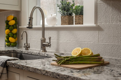 Eat-in kitchen - mid-sized transitional galley medium tone wood floor and brown floor eat-in kitchen idea in Boston with an undermount sink, beaded inset cabinets, beige cabinets, quartz countertops, white backsplash, ceramic backsplash, paneled appliances, an island and multicolored countertops