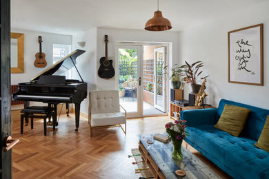 Inspiration for a small modern enclosed living room in London with a music area, white walls, light hardwood flooring and no fireplace.