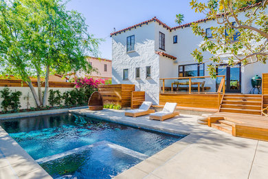 Mid-sized tuscan backyard concrete and rectangular lap hot tub photo in Los Angeles