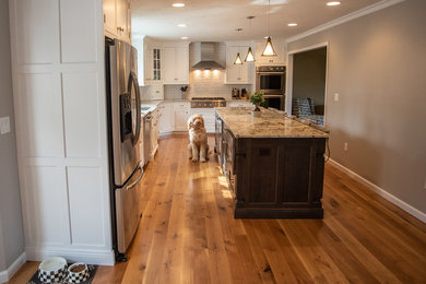 Mid-sized transitional medium tone wood floor eat-in kitchen photo in New York with an undermount sink, white cabinets, granite countertops, white backsplash, stainless steel appliances and an island