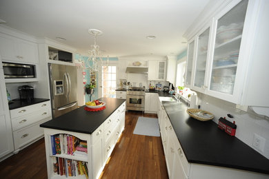 Inspiration for a large transitional u-shaped medium tone wood floor enclosed kitchen remodel in Baltimore with a farmhouse sink, glass-front cabinets, white cabinets, soapstone countertops, white backsplash, subway tile backsplash, stainless steel appliances and an island