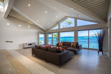 Photo of a large contemporary formal enclosed living room in Hawaii with white walls, porcelain floors, no tv and beige floor.