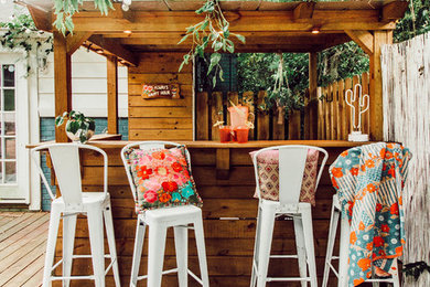 Eclectic backyard deck photo in Nashville with a pergola