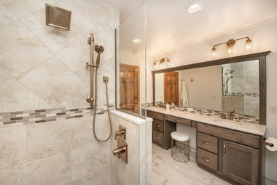 Inspiration for a large timeless master beige tile and porcelain tile porcelain tile, beige floor and double-sink bathroom remodel in Milwaukee with recessed-panel cabinets, medium tone wood cabinets, a two-piece toilet, white walls, an undermount sink, quartz countertops, a hinged shower door, beige countertops and a built-in vanity