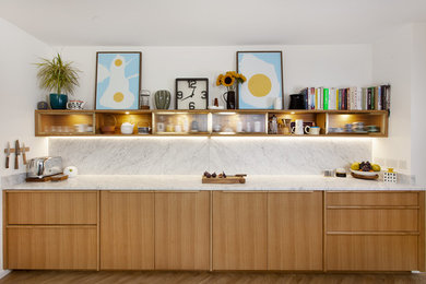Photo of a medium sized victorian galley kitchen/diner in Other with a submerged sink, flat-panel cabinets, medium wood cabinets, marble worktops, white splashback, marble splashback, stainless steel appliances, light hardwood flooring, no island, brown floors and white worktops.