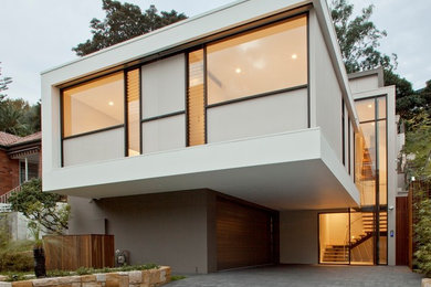 This is an example of a contemporary three-storey stucco multi-coloured house exterior in Sydney with a flat roof.