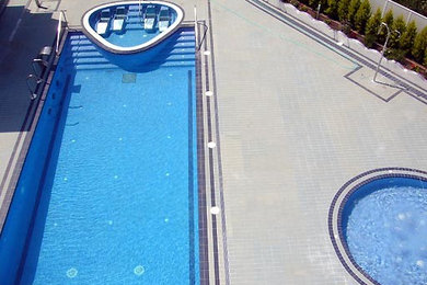 Foto de piscinas y jacuzzis alargados minimalistas grandes rectangulares en patio con suelo de baldosas