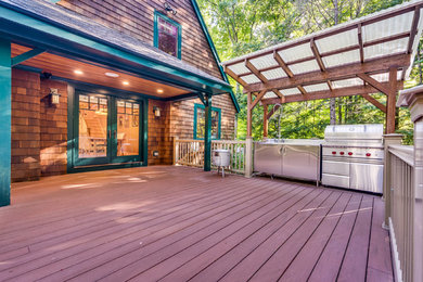 Design ideas for a mid-sized arts and crafts backyard deck in Boston with an outdoor kitchen and a roof extension.