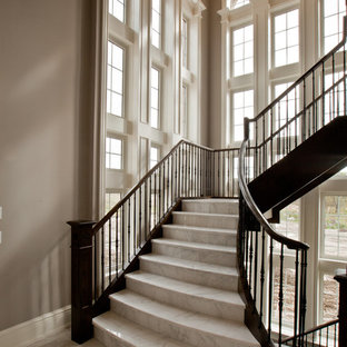 Photo of an expansive traditional l-shaped staircase in Toronto with marble treads and marble risers.
