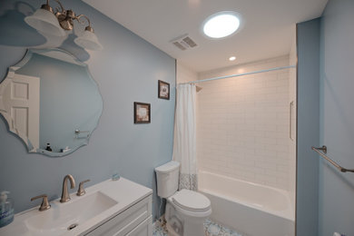 Example of a mid-sized classic white tile and ceramic tile single-sink bathroom design in New York with shaker cabinets, white cabinets, a two-piece toilet, an undermount sink and granite countertops