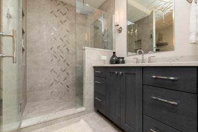 Example of a mid-sized transitional master porcelain tile, gray floor and single-sink double shower design in Other with recessed-panel cabinets, gray cabinets, a two-piece toilet, gray walls, an undermount sink, quartz countertops, a hinged shower door, gray countertops and a freestanding vanity