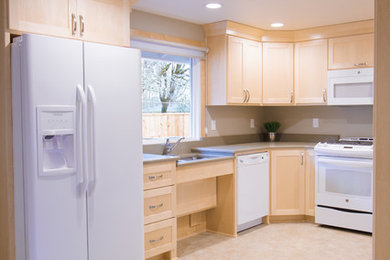 Mid-sized transitional u-shaped vinyl floor and multicolored floor enclosed kitchen photo in Portland with an undermount sink, shaker cabinets, light wood cabinets, quartz countertops, white appliances, no island and gray countertops