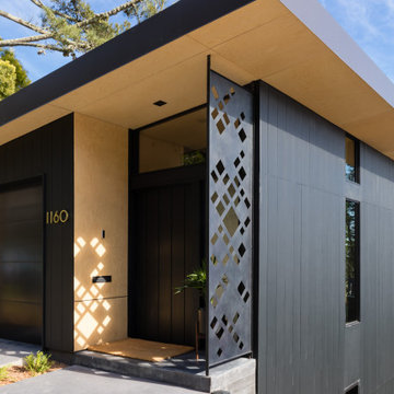 Modern front entry with custom geometric laser-cut steel screen and wood soffit