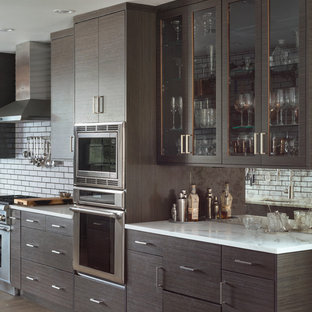 This is an example of a mid-sized contemporary single-wall kitchen pantry in Other with flat-panel cabinets, brown cabinets, blue splashback, subway tile splashback, stainless steel appliances and with island.