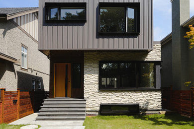 Foto de fachada de casa gris y negra minimalista de tamaño medio de tres plantas con revestimiento de metal, tejado a dos aguas y tejado de metal