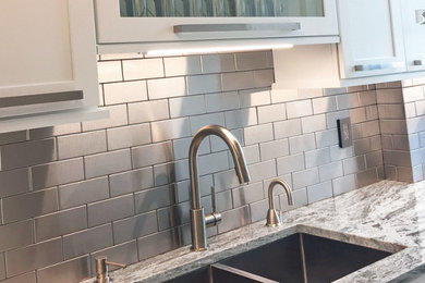 Kitchen - transitional kitchen idea in New York with white cabinets, metal backsplash, stainless steel appliances, an undermount sink, shaker cabinets and metallic backsplash