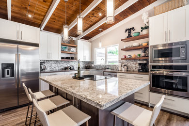 Example of a mid-sized trendy l-shaped open concept kitchen design in Hawaii with a farmhouse sink, shaker cabinets, quartz countertops, stainless steel appliances and an island