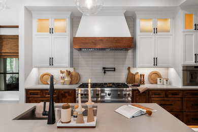 Inspiration for a transitional l-shaped kitchen remodel in Dallas with stainless steel appliances, an island and beige countertops
