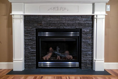Elegant light wood floor living room photo in Vancouver with beige walls, a standard fireplace and a stone fireplace