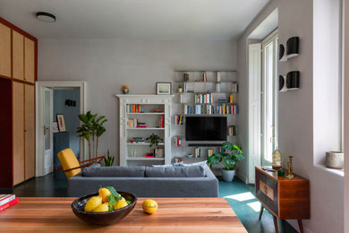 Foto de salón de tamaño medio con paredes grises y pared multimedia