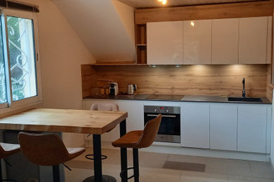 マルセイユにある高級な小さなコンテンポラリースタイルのおしゃれなキッチン (シングルシンク、インセット扉のキャビネット、白いキャビネット、ラミネートカウンター、木材のキッチンパネル、パネルと同色の調理設備、マルチカラーのキッチンカウンター) の写真