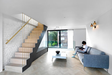 This is an example of a mid-sized contemporary open concept living room in London with white walls and painted wood floors.