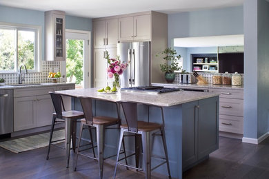 Example of a mid-sized trendy l-shaped medium tone wood floor and brown floor eat-in kitchen design in Denver with an undermount sink, recessed-panel cabinets, gray cabinets, granite countertops, multicolored backsplash, cement tile backsplash, stainless steel appliances, an island and multicolored countertops