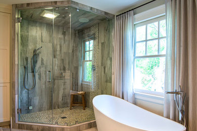 Inspiration for a mid-sized transitional master bathroom in Charleston with shaker cabinets, white cabinets, a freestanding tub, a corner shower, a one-piece toilet, beige tile, porcelain tile, porcelain floors, an undermount sink, engineered quartz benchtops, beige walls, beige floor and a hinged shower door.