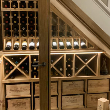 Bespoke under stairs wine room with glass front in Oxfordshire