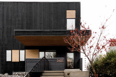 Mid-sized minimalist black two-story wood exterior home photo in Other with a white roof