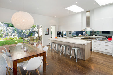 Large contemporary open plan dining in Melbourne with white walls, dark hardwood floors and no fireplace.