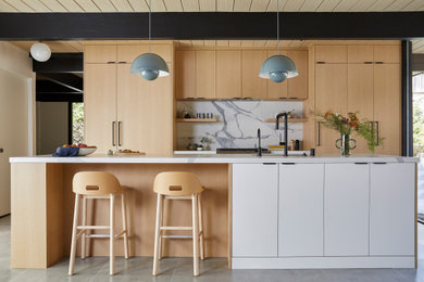 Inspiration for a small 1960s single-wall porcelain tile, gray floor and wood ceiling eat-in kitchen remodel in San Francisco with an undermount sink, flat-panel cabinets, light wood cabinets, quartz countertops, white backsplash, quartz backsplash, paneled appliances, an island and white countertops