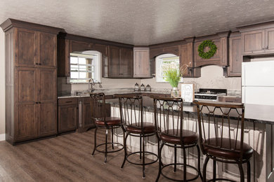L-shaped eat-in kitchen photo in Other with an undermount sink, raised-panel cabinets, granite countertops and an island