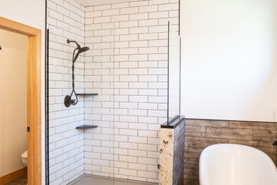 Modelo de cuarto de baño rural con bañera con patas, paredes blancas, suelo vinílico, encimera de ónix y ducha abierta
