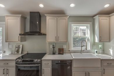Inspiration for a mid-sized transitional single-wall light wood floor and brown floor eat-in kitchen remodel in Raleigh with quartz countertops, an island, white countertops, a farmhouse sink, black appliances, recessed-panel cabinets and white cabinets